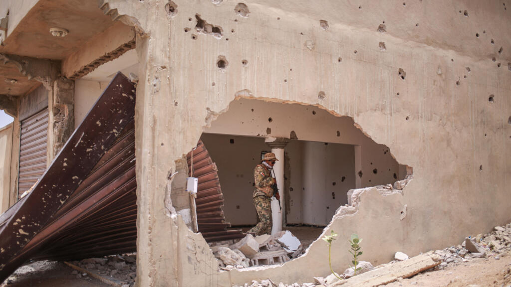 Un soldat du Front national de libération de l'Azawad (FLA) se promène dans un bâtiment endommagé à Kidal, illustrant les conséquences des attaques du 25 avril 2026.