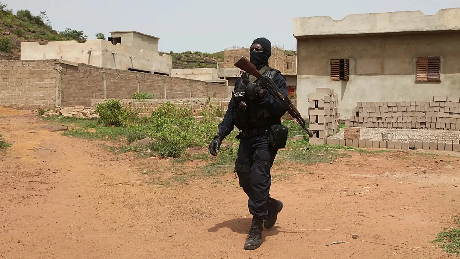 Un policier malien patrouille devant le Campement Kangaba, un complexe touristique près de Bamako