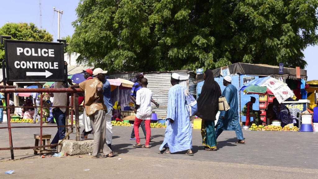 À Karang, au Sénégal, des voyageurs franchissent le poste de contrôle policier pour se rendre en Gambie, en mai 2016.
